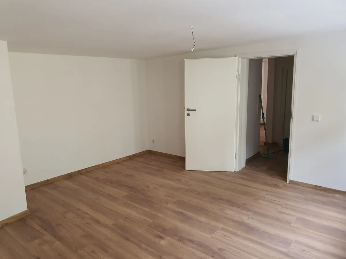 Sanierter Raum mit neuer Zimmertür und neuem Boden