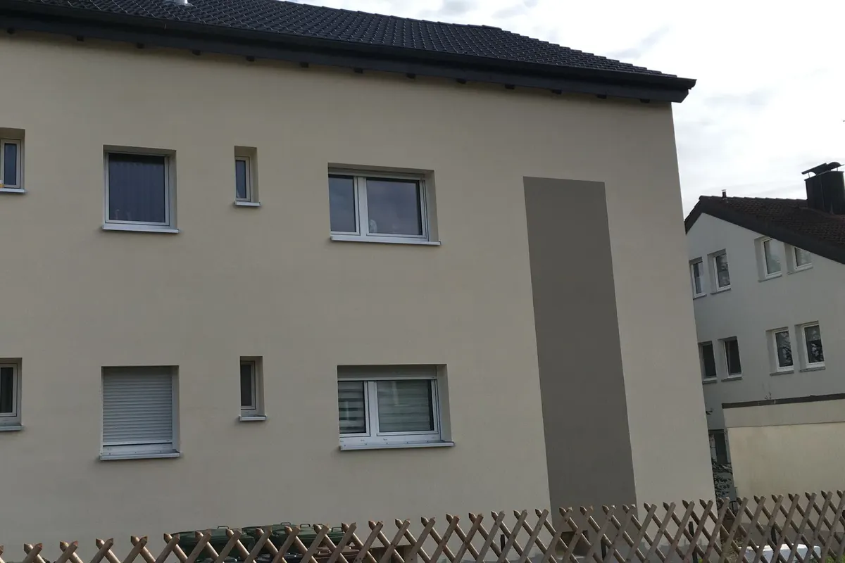 Frisch verputzte Hausfassade mit Farbakzent-Feld