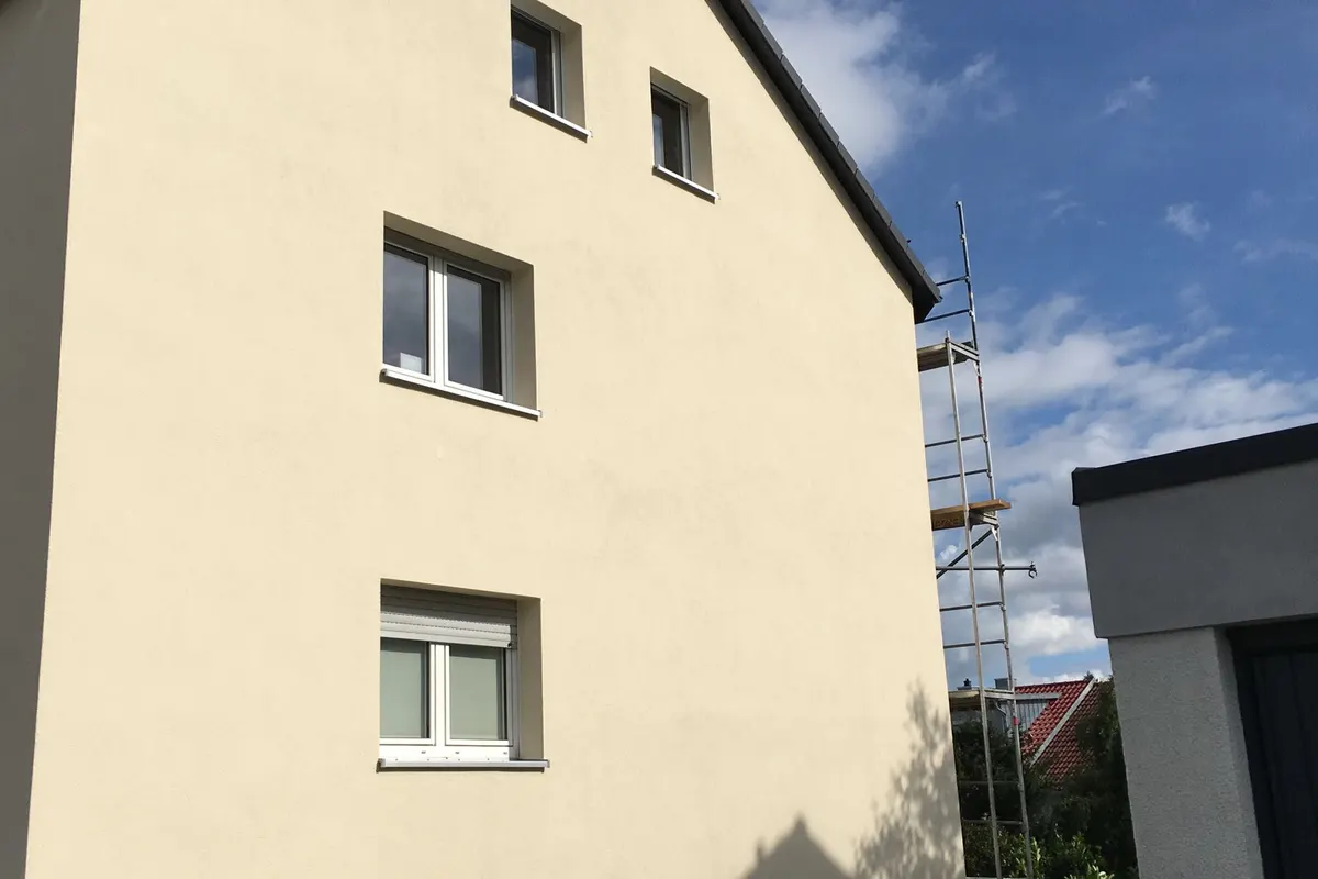 Verputzter Hausgiebel mit sauberen Fensterlaibungen