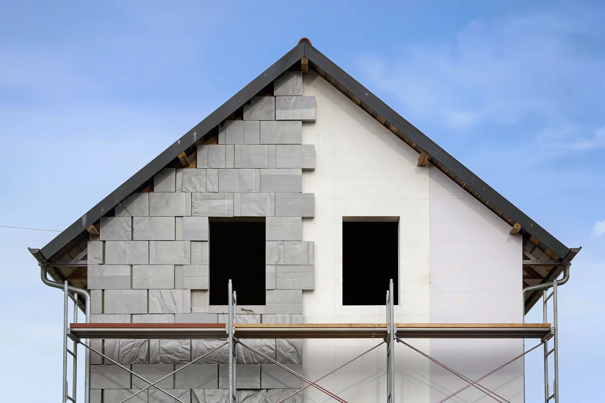 Dämmplatte wird bei der WDVS-Montage an die Fassade gedrückt